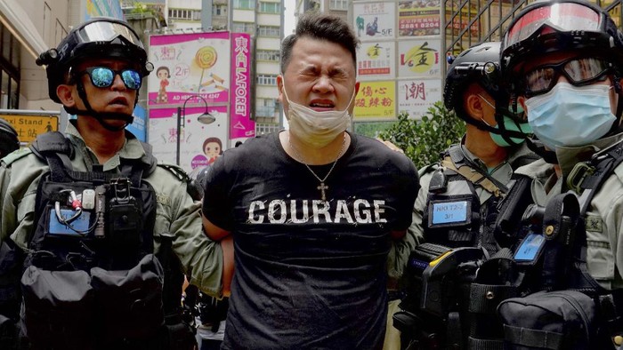 Police detain protesters after a protest in Causeway Bay before the annual handover march in Hong Kong, Wednesday, July. 1, 2020. Hong Kong marked the 23rd anniversary of its handover to China in 1997, and just one day after China enacted a national security law that cracks down on protests in the territory. Hong Kong police said on Facebook they had arrested over 30 people on various charges, from unlawful assembly to the violation of a national security law on the first day of the law. (AP Photo/Kin Cheung)