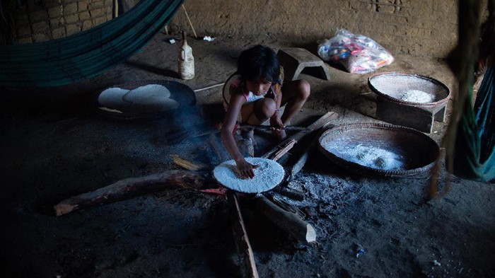 Potret Kehidupan Suku Yanomami di Tengah Pandemi RORAIMA, BRAZIL - JUNE 30: Yanomamis woman cooks indoors at the Auaris on June 30, 2020 in Roraima, Brazil. The Yanomamis live in regions of difficult access and have 25 thousand Indians. Brazil has over 1,402,000 confirmed positive of Coronavirus cases, with 147 among Yanomamis, and 59,594 deaths across the country and 4 among Yanomamis. (Photo by Andressa Anholete / Getty Images)