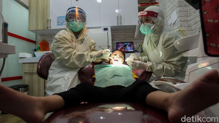 Dokter Gigi Anak Beroperasi Pakai APD di Era New Normal Sejumlah protokol kesehatan diterapkan di klinik khusus anak-anak di Jakarta. Salah satunya para dokter disana kenakan alat pelindung diri saat bertugas.