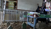 Pengajar memberikan materi kepada anak-anak di Balla Pendidikan (Rumah Pendidikan) di lahan Tempat Pemakaman Umum (TPU) Dadi yang berada di kawasan Makassar, Sulawesi Selatan.