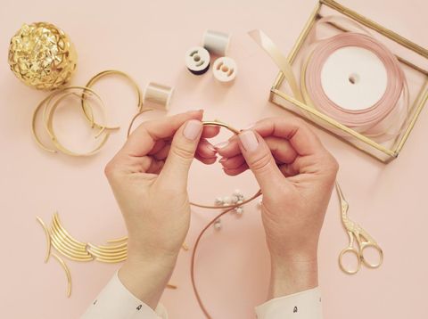 perhiasan Jewelry designer workplace. Woman hands making handmade jewelry. Freelance fashion femininity workspace in flat lay style. Pastel pink and gold