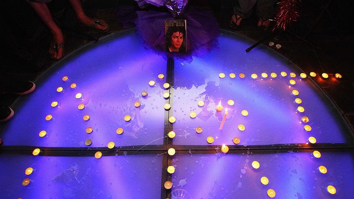 BEIJING - JUNE 26:  Chinese fans of Michael Jackson piece out the letter MJ with the candles as they gathered at a bar to commemorate him on June 26, 2009 in Beijing, China. Jackson, 50, the iconic pop star, died after going into cardiac arrest in a hospital on June 25 in Los Angeles, California.  (Photo by Feng Li/Getty Images)