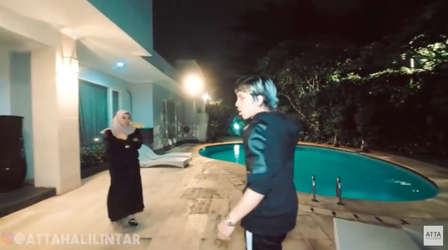 Halaman belakang dilengkapi sebuah kolam renang yang menurut Atta konsepnya mirip villa-villa di Bali. Kebetulan yang punya dulu orang Bali, ungkap aktris yang kini menggeluti usaha kuliner dan jilbab itu. (Foto: YouTube/Atta Halilintar)