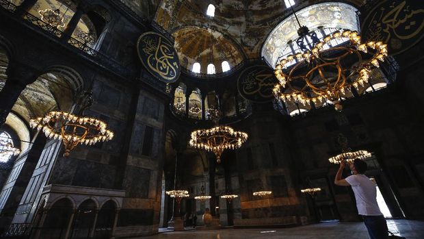People visit the Byzantine-era Hagia Sophia, one of Istanbul's main tourist attractions in the historic Sultanahmet district of Istanbul on Thursday, June 25, 2020. The 6th-century building is now at the center of a heated debate between conservative groups who want it to be reconverted into a mosque and those who believe the World Heritage site should remain a museum. (AP Photo/Emrah Gurel)