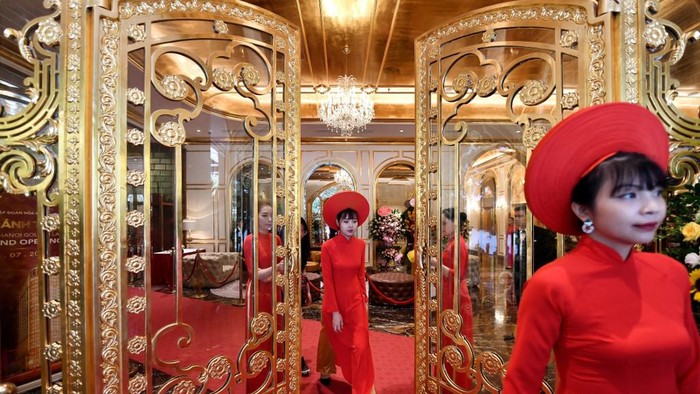 Staff wait to welcome guests in the lobby of the newly-inaugurated Dolce Hanoi Golden Lake hotel, the worlds first gold-plated hotel, in Hanoi on July 2, 2020. (Photo by Manan VATSYAYANA / AFP)