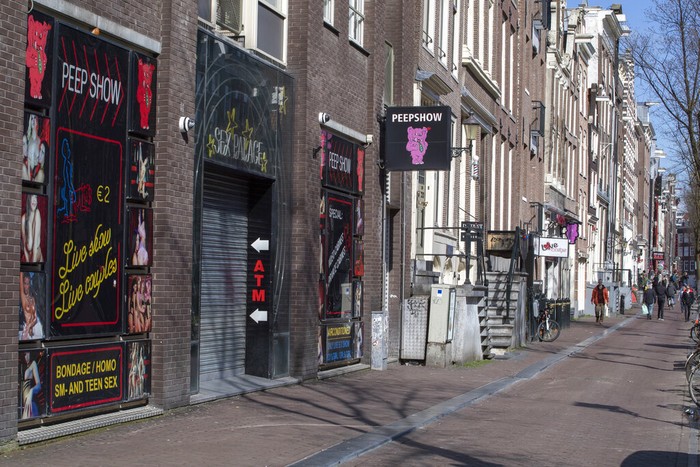 Virus Outbreak Netherlands Red Light District Oude Kerk, or Old Church, is reflected in the window of the PIC, Prostitution Information Center, as sex workers welcomed clients again in the Red Light District in Amsterdam, Netherlands, Wednesday, July 1, 2020. It wasn't quite business as usual as the capital's Red Light District emerged from coronavirus lockdown, but it was as close as it has been since the pandemic slammed the brakes on the world's oldest profession. (AP Photo/Peter Dejong)