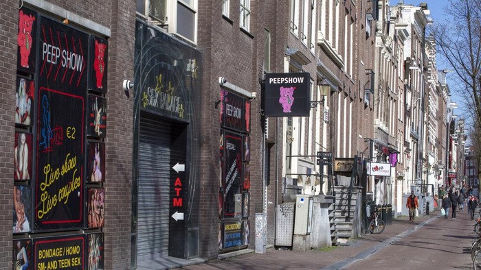 Oude Kerk, or Old Church, is reflected in the window of the PIC, Prostitution Information Center, as sex workers welcomed clients again in the Red Light District in Amsterdam, Netherlands, Wednesday, July 1, 2020. It wasnt quite business as usual as the capitals Red Light District emerged from coronavirus lockdown, but it was as close as it has been since the pandemic slammed the brakes on the worlds oldest profession. (AP Photo/Peter Dejong)