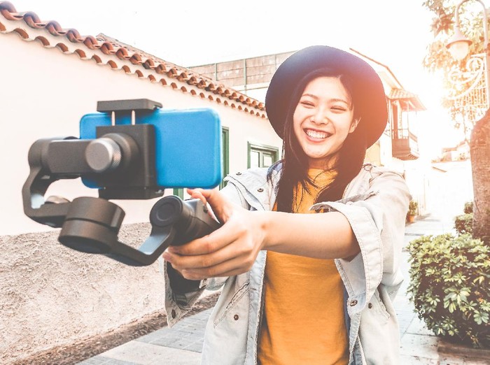 Happy asian woman vlogging with gimbal tripod and smartphone - Influencer chinese girl having fun with new trend technology - Millennial generation activity job, youth and tech concept - Focus on face