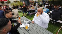 Sejumlah pub maupun restoran yang sebelumnya ditutup dan sepi dari aktivitas kini kembali bergeliat usai lockdown dilonggarkan. AP Photo/Frank Augstein.