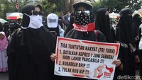 Dalam aksi tersebut sejumlah warga tampak membawa poster berisi tuntutan mereka, salah satunya menolak pembahasan RUU HIP.
