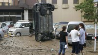 Sebuah mobil terbalik akibat diterjang banjir, Senin (6/7).