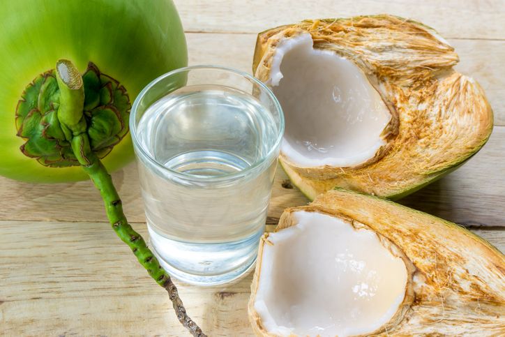 Tropical green coconuts opened for the drinking water with straws.