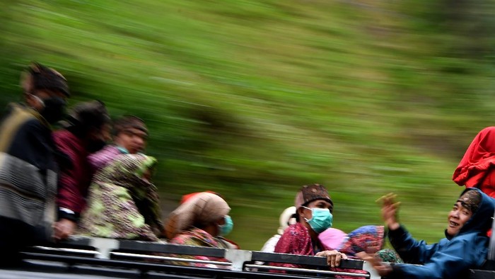 Masyarakat Suku Tengger dengan mengenakan masker berada di mobil bak terbuka menuju kawasan Gunung Bromo untuk melaksanakan perayaan Yadnya Kasada, Probolinggo, Jawa Timur, Senin (6/7/2020). Perayaan Yadnya Kasada merupakan bentuk ungkapan syukur masyarakat Suku Tengger dengan melarung sesaji berupa hasil bumi dan ternak ke kawah Gunung Bromo. ANTARA FOTO/Zabur Karuru/hp.