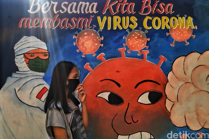 Warga melintas di depan mural bertemakan Lawan COVID-19 di kawasan Rawa Badak Selatan, Jakarta Utara, Senin (6/7). Menurut keterangan warga mural tersebut merupakan aksi lomba membuat mural bertemakan COVID-19 dengan tujuan mengkampanyekan untuk selalu menerapkan protkoler kesehatan di era New Normal.