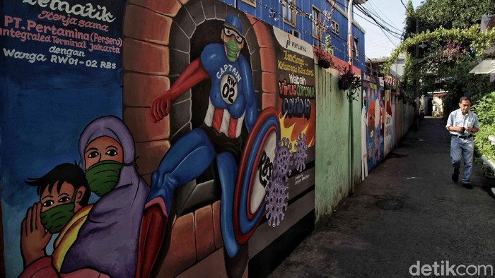 Warga melintas di depan mural bertemakan ''Lawan COVID-19'' di kawasan Rawa Badak Selatan, Jakarta Utara, Senin (6/7). Menurut keterangan warga mural tersebut merupakan aksi lomba membuat mural bertemakan COVID-19 dengan tujuan mengkampanyekan untuk selalu menerapkan protkoler kesehatan di era New Normal.