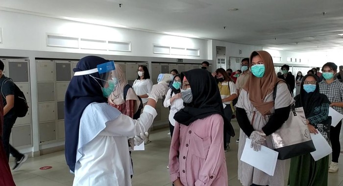 Peserta UTBK diperiksa suhu tubuhnya sebelum memasuki ruangan ujian, di Gedung RIk, UI, Depok, Jawa Barat, Senin (6/7/2020).