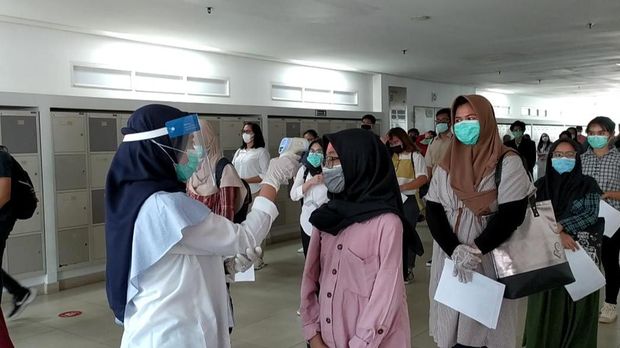 Peserta UTBK diperiksa suhu tubuhnya sebelum memasuki ruangan ujian, di Gedung RIk, UI, Depok, Jawa Barat, Senin (6/7/2020).