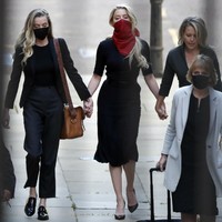 Bintang Aquaman itu tak datang sendiri. Ia didampingi adiknya, Whitney Heard (kiri), dan pengacaranya, Jennifer Robinson. Mereka berjalan menuju gedung persidangan sambil bergandengan tangan. (Foto: AP Photo/Alastair Grant)