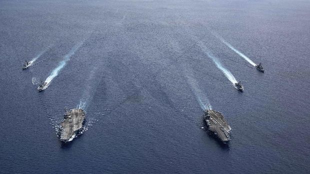 In this photo provided by U.S. Navy, the USS Ronald Reagan (CVN 76) and USS Nimitz (CVN 68) Carrier Strike Groups steam in formation, in the South China Sea, Monday, July 6, 2020. China on Monday, July 6, accused the U.S. of flexing its military muscles in the South China Sea by conducting joint exercises with two U.S. aircraft carrier groups in the strategic waterway.(Mass Communication Specialist 3rd Class Jason Tarleton/U.S. Navy via AP)