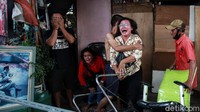 Beberapa warga berusaha menenangkan pemilik kios yang menangis histeris tersebut.