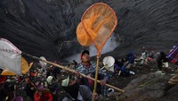 Warga berebut sesaji yang dilempar oleh masyarakat Suku Tengger ke kawah Gunung Bromo dalam rangka perayaan Yadnya Kasada, Probolinggo, Jawa Timur, Selasa (7/7/2020). ANTARA FOTO/Zabur Karuru.