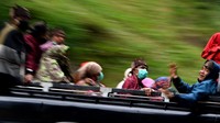 Masyarakat Suku Tengger dengan mengenakan masker berada di mobil bak terbuka menuju kawasan Gunung Bromo untuk melaksanakan perayaan Yadnya Kasada, Probolinggo, Jawa Timur, Senin (6/7/2020). ANTARA FOTO/Zabur Karuru.