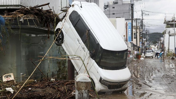 This aerial photo shows an overturned car at paddy field following a heavy rain in Hitoyoshi, Kumamoto prefecture, southern Japan  Sunday, July 5, 2020. Deep floodwaters and the risk of more mudslides hampered search and rescue operations on Sunday in southern Japan, including at elderly home facilities where more than a dozen perished and scores are still stranded. (Kyodo News via AP)