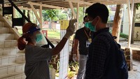 Para peserta dicek suhu tubuhnya sebelum mengikuti Ujian Tulis Berbasis Komputer (UTBK) di Universitas Indonesia (UI).