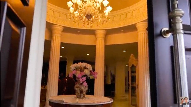 Di balik pintu utama, terdapat sebuah foyer yang dikelilingi beberapa pilar. Sebuah lampu gantung semakin mempertegas atmosfer kemegahan rumah. (Foto: YouTube/Baim Paula)
