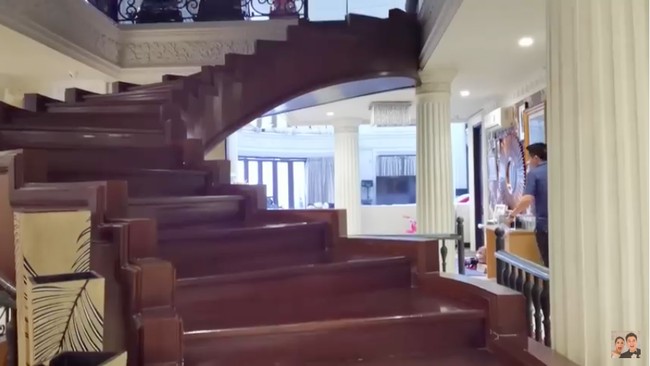 Salah satu keunikan di rumah ini adalah tangga kayu tanpa pegangan dengan warna coklatnya yang kontras. (Foto: YouTube/Baim Paula)