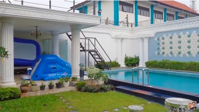 Halaman belakang dilengkapi sebuah taman yang cukup luas dan sebuah kolam renang. (Foto: YouTube/Baim Paula)