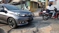 Pengendara harus melambatkan laju kendaraannya saat melintas di jalan yang rusak tersebut.