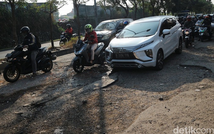 Pengendaran melewati jalan rusak di Jalan I Gusti Ngurah Rai, Bintara, Kota Bekasi, Jawa Barat, Rabu (8/7/2020). Jalan penghubung kota Bekasi dan Jakarta di beberapa titik mengalami kerusakan. Salah satunya di Jalan I Gusti Ngurah Rai, tepatnya di RT 006 RW 014, Kelurahan Bintara, Bekasi Barat, Jawa Barat. Jalan disini berlubang cukup dalam yang mengharuskan pengendara berhati-hati. Kerusakan ini disebabkan buruknya drainase dikawasan tersebut. Kerusakan sudah terjadi sejak bulan Januari hingga kini tidak ada perbaikan.