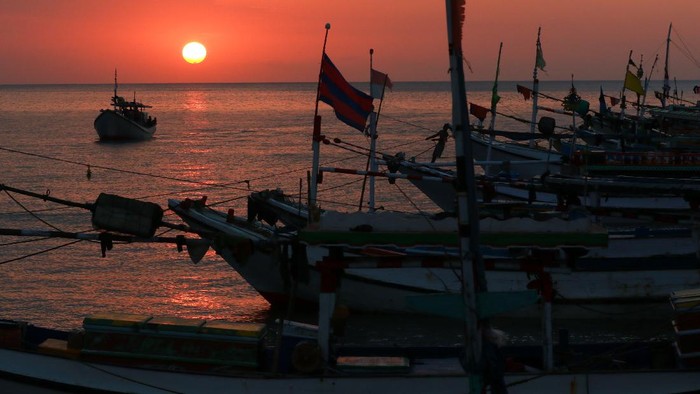 Kapal melintas saat matahari terbenam di dermaga Penarukan, Situbondo, Jawa Timur, Selasa (7/7/2020). Dermaga Penarukan yang difungsikan untuk bongkar muat hasil tangkapan nelayan dan angkutan barang ke kepulauan madura itu, juga ramai dikunjungi warga untuk melihat matahari terbenam. ANTARA FOTO/Budi Candra Setya/hp.