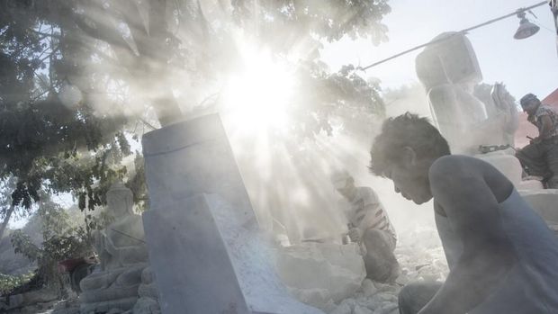 This photo taken on December 22, 2018 shows workers polishing a Buddha statue in Sagyin village on the banks of the Ayeyerwady River in Madaya township, about 46 kms from Mandalay. - Sagyin village is known for producing marble statues, most of which are sold to Chinese traders, with the rest exported to Thailand, Vietnam and Taiwan. (Photo by YE AUNG THU / AFP)