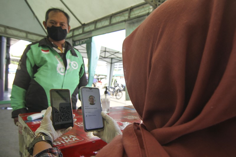 Petugas menyemprotkan cairan disinfektan kepada kendaraan pengemudi ojek online sebelum membawa penumpang di Shalter Depok Baru, Depok, Jawa Barat, Selasa (7/7/2020). Pemerintah Kota Depok mulai hari ini kembali memperbolehkan ojek online membawa penumpang dengan syarat mematuhi protokol kesehatan. ANTARA FOTO/Asprilla Dwi Adha/hp.