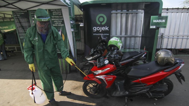 Petugas menyemprotkan cairan disinfektan kepada kendaraan pengemudi ojek online sebelum membawa penumpang di Shalter Depok Baru, Depok, Jawa Barat, Selasa (7/7/2020). Pemerintah Kota Depok mulai hari ini kembali memperbolehkan ojek online membawa penumpang dengan syarat mematuhi protokol kesehatan. ANTARA FOTO/Asprilla Dwi Adha/hp.