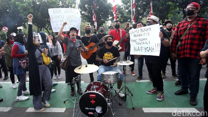 Potret Musisi Kafe 'Ngamen' di Balai Kota Jakarta Sejumlah musisi kafe gelar aksi di depan Balai Kota Jakarta. Mereka desak Gubernur Jakarta Anies Baswedan izinkan penampilan musik di kafe di masa PSBB transisi