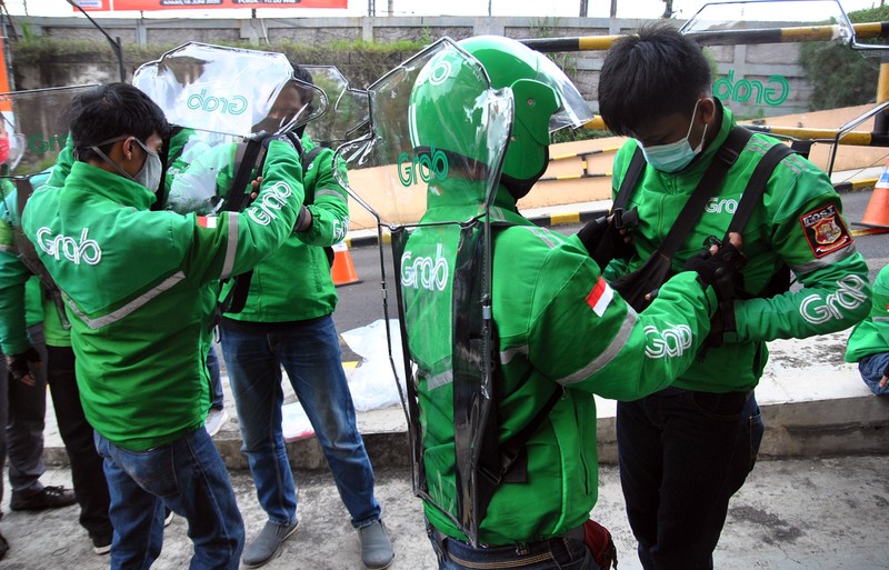 Pengemudi ojek daring menggunakan sekat pembatas dengan penumpang saat pembagian gratis di Mall BTM, Kota Bogor, Jawa Barat, Rabu (8/7/2020). Pemerintah Kota Bogor mulai mengijinkan kembali ojek daring beroperasi membawa penumpang dengan protokol kesehatan pencegahan penyebaran pandemi COVID-19 saat pra Adaptasi Kehidupan Baru (AKB). ANTARA FOTO/Arif Firmansyah/foc.