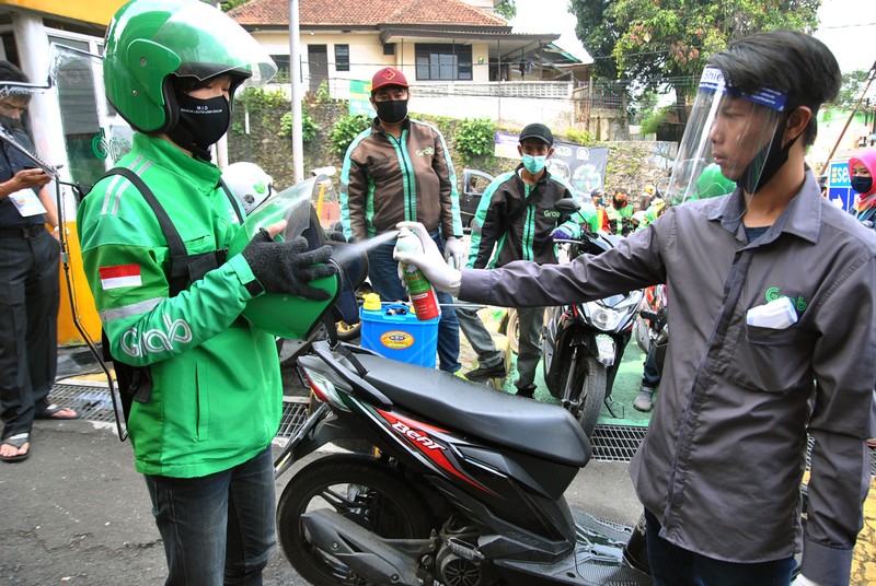 Pengemudi ojek daring menggunakan sekat pembatas dengan penumpang saat pembagian gratis di Mall BTM, Kota Bogor, Jawa Barat, Rabu (8/7/2020). Pemerintah Kota Bogor mulai mengijinkan kembali ojek daring beroperasi membawa penumpang dengan protokol kesehatan pencegahan penyebaran pandemi COVID-19 saat pra Adaptasi Kehidupan Baru (AKB). ANTARA FOTO/Arif Firmansyah/foc.