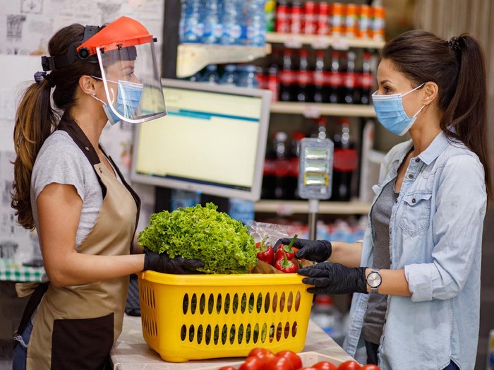 465369134 Close-up of woman checking shopping list with apples in the background