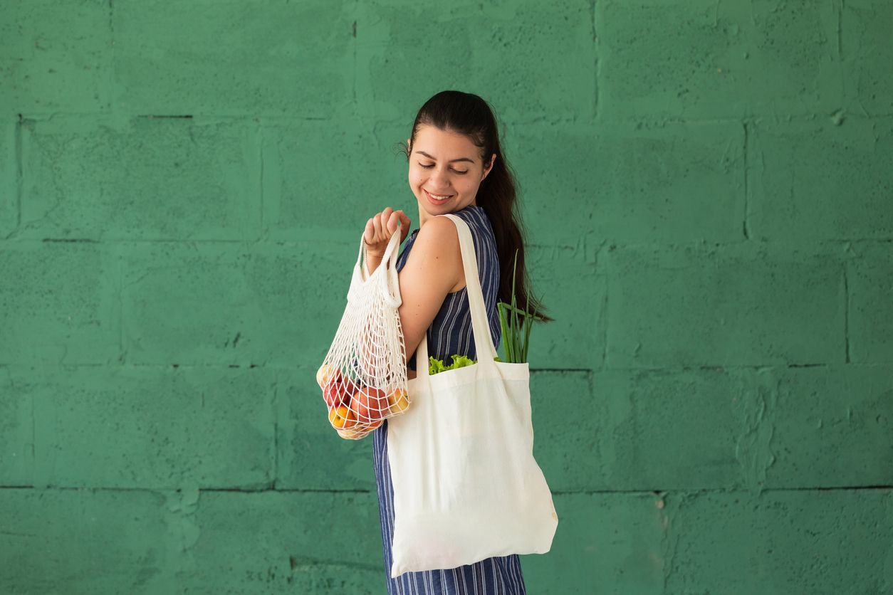 Close-up of woman checking shopping list with apples in the background