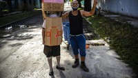 Untuk bagian kepala, dia menggunakan kardus bekas kotak kue sehingga membuatnya tampak seperti atap.     