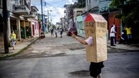 Pensiunan berusia 82 tahun itu berjalan di jalanan Havana mengenakan kotak kardus.  