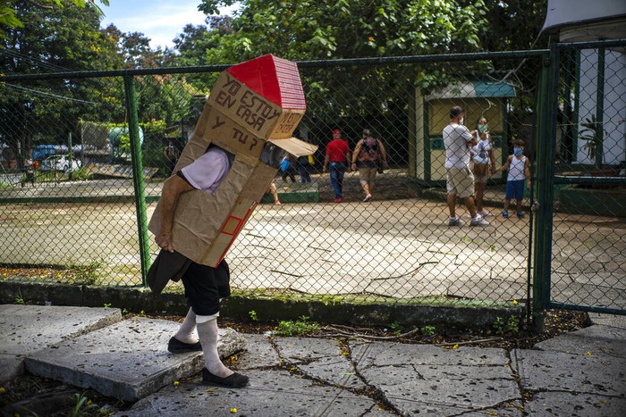 APTOPIX Virus Outbreak Cuba Feridia Rojas, a retired nurse, wears a cardboard box as a protective measure against the spread of the new coronavirus, in Havana, Cuba, Wednesday, July 8, 2020. The 82-year-old pensioner shuffles through the streets of Havana on shopping excursions wearing the cardboard box, with a handwritten message that reads in Spanish: