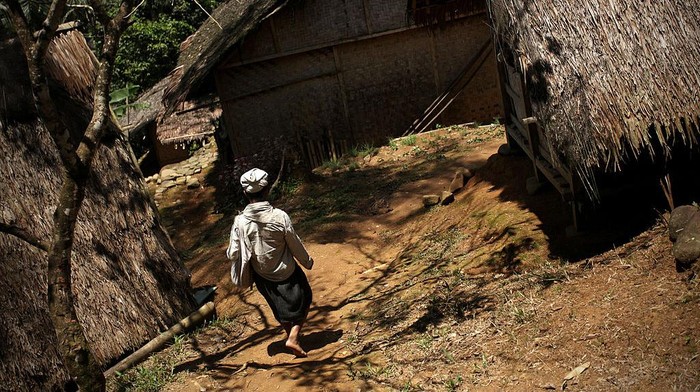 BANTEN, INDONESIA - FEBRUARY 07:  A member of the traditional Baduy (or Badui) tribe walks on the bamboo bridge in the village in the hilly forest area of the Kendeng mountains on February 7, 2010 in Banten, Indonesia. The traditional community consists of around 5000-8000 people spread acorss a hilly area of just 50 square kilometres. The religion of the Baduy people, known as Agama Sunda Wiwitan, combines elements of Hinduism, Buddhism and traditional beliefs, including various taboos such as not eating food at night, touching money, accepting gold or silver or even cutting their hair.  (Photo by Ulet Ifansasti/Getty Images)