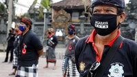 Para pecalang yang berjaga pun tetap menjaga jarak dan memakai masker guna menekan laju penyebaran virus COVID-19.