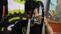 Dengan sangat teliti para mekanik tengah mereparasi salah satu bagian sepeda.