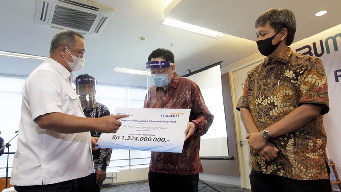 Direktur Utama Bank Mandiri Royke Tumilaar (kanan) dan Wakil Direktur Utama Bank Mandiri Hery Gunardi (kiri) sedang berbincang dengan debitur penerima kredit modal kerja (KMK) dalam program Pemulihan Ekonomi Nasional (PEN) di Bintaro, Banten. Mendukung program PEN dari dampak covid-19, Bank Mandiri mengalokasikan Rp30 triliun untuk penyaluran kredit produktif ke segmen UMKM dan Wholesale dengan fokus pada usaha padat karya dan yang mendukung ketahanan pangan.