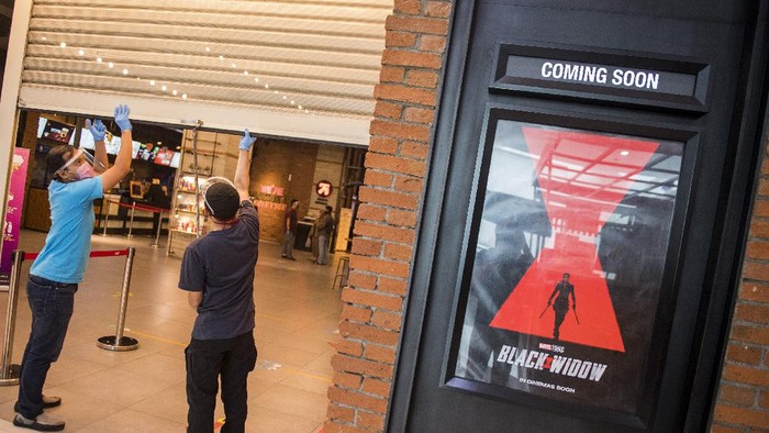 Pekerja memasang tanda jaga jarak saat simulasi pembukaan dan peninjauan tempat hiburan bioskop CGV Cinemas di Bandung Electronic Center (BEC), Bandung, Jawa Barat, Kamis (9/7/2020). Simulasi tersebut dilakukan dalam rangka peninjauan kesiapan tempat hiburan bioskop dalam penerapan protokol kesehatan seperti penggunaan alat pelindung wajah bagi karyawan, pembatas jaga jarak, masker, sarung tangan dan cairan disinfektan seiring tatanan normal baru di tengah pandemi COVID-19. ANTARA FOTO/M Agung Rajasa/aww.